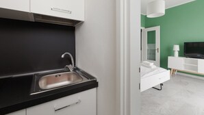 A modern bathroom with a white sink, mirror, and white cabinet.
