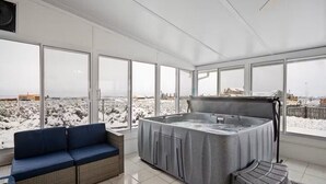 Ein moderner Innenraum mit großen Fenstern, einer Whirlwanne und einem Sofa.
