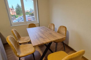 Comedor con una mesa de madera y cuatro sillas amarillas.