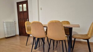 Ein Essbereich mit einem Holztisch und vier Stühlen mit schwarzen Beinen.