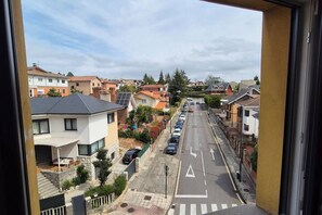 A residential street with houses, parked cars, and a clear sky. - 648C1 Apartamento Mareval (Oviedo)