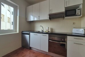A kitchen with white cabinets, a dishwasher, a microwave, and a toaster. - 648C1 Apartamento Mareval (Oviedo)