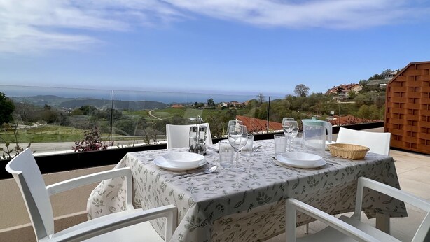 A table set outdoors with a view of the countryside and hills.