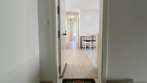A hotel hallway with a welcome mat, a sign indicating a VIP room, and a dining area with chairs and a table. - Cozy apartmet in Hoznayo (Entrambasaguas)