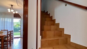 Una escalera de madera con barandilla que lleva a un piso superior.