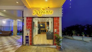 L’extérieur d’un hôtel appelé « Nivanta », avec un espace de réception visible à travers l’entrée.