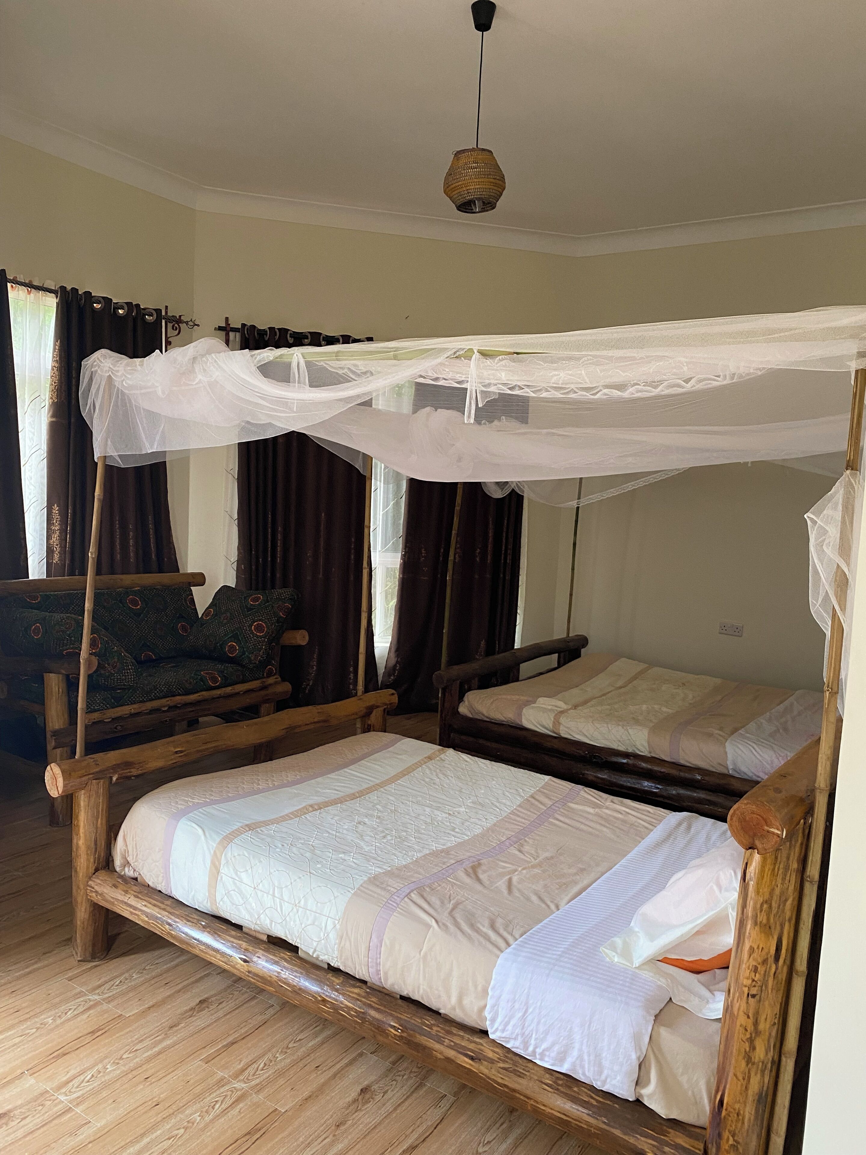 Una habitación tradicional con estructura de cama de madera, dosel y una lámpara colgante.