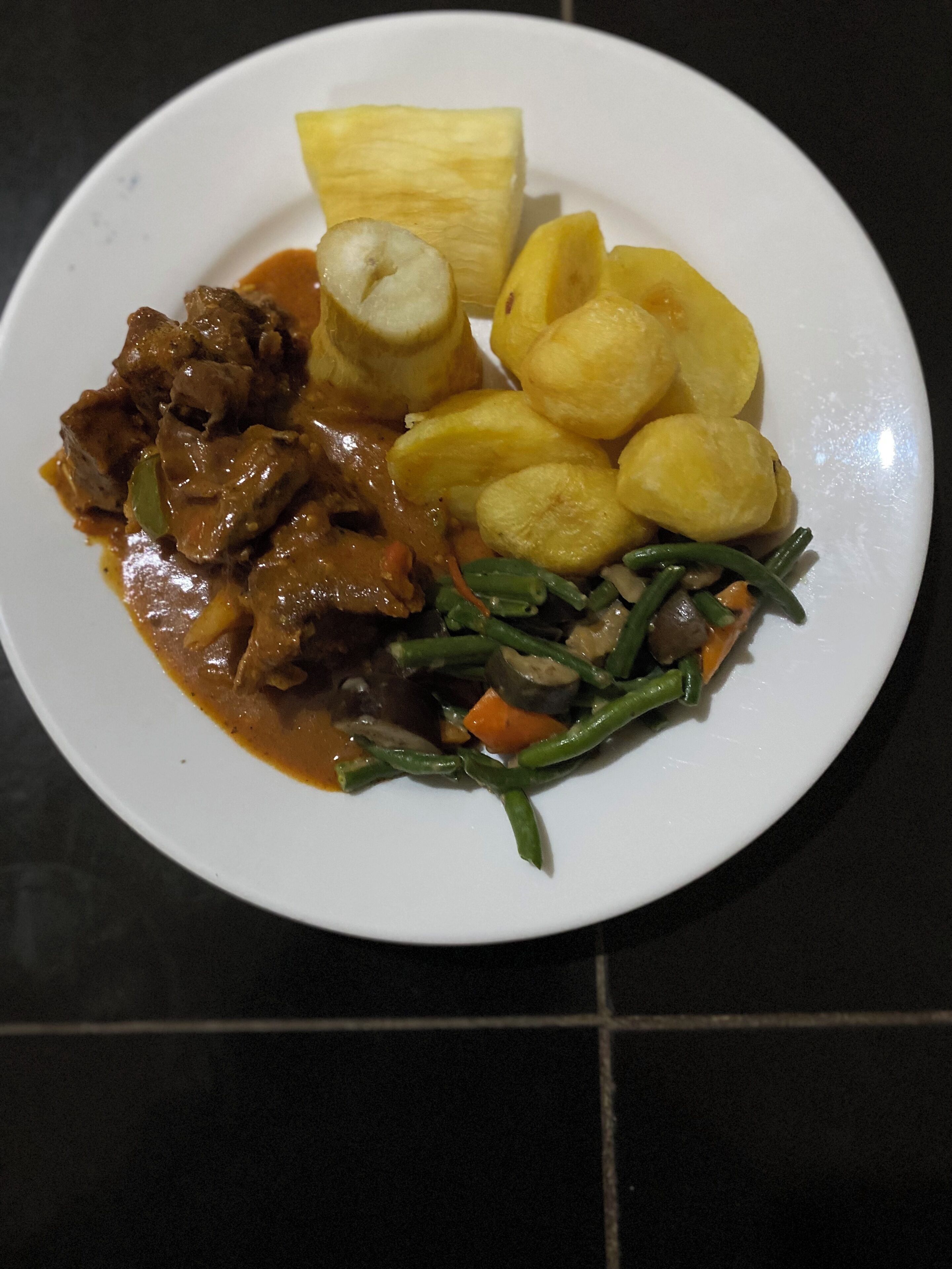 A plate of food with meat, potatoes, and green beans.