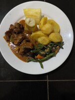 A plate of food with meat, potatoes, and green beans.