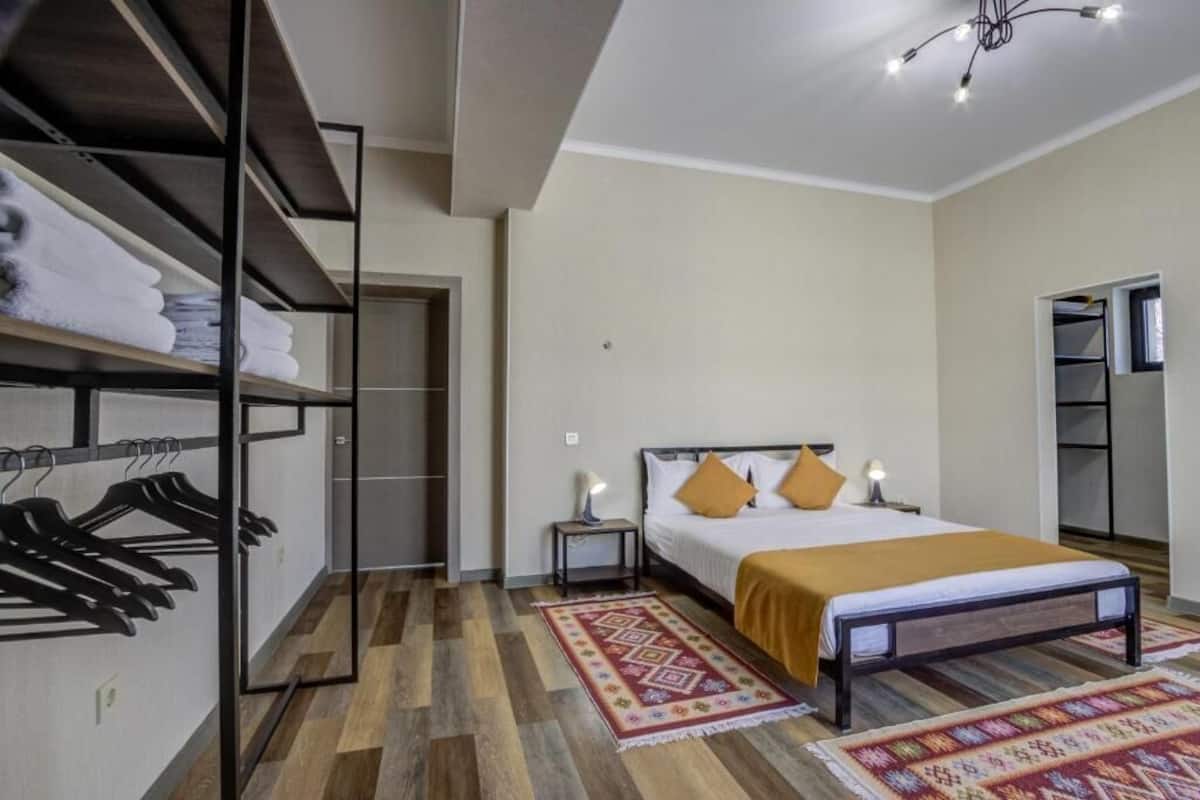 Une chambre à coucher comprenant un lit, une table de chevet, une armoire et un porte-serviettes.