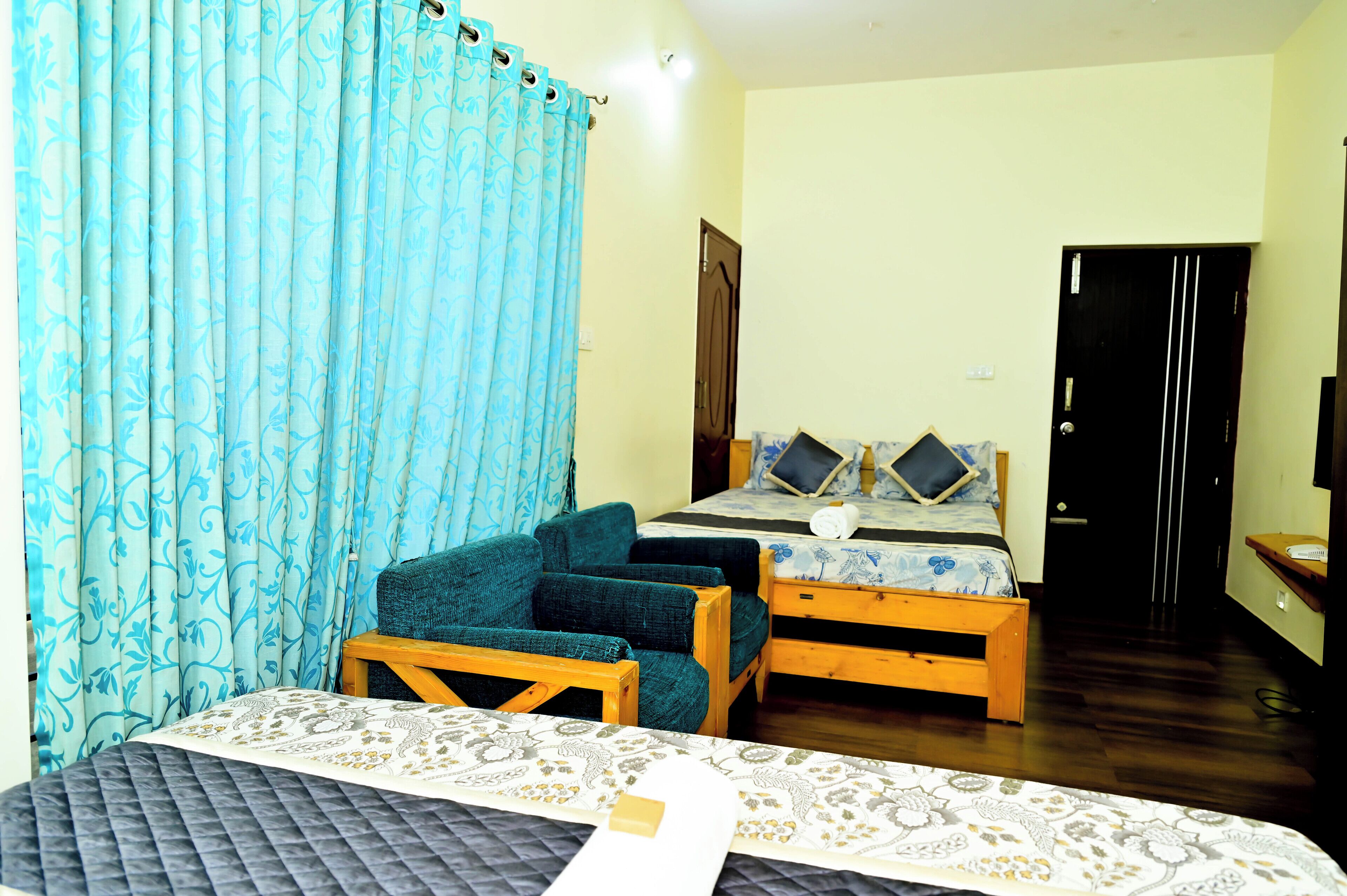 A bedroom with a bed, a wooden bench, a chair, and a desk.