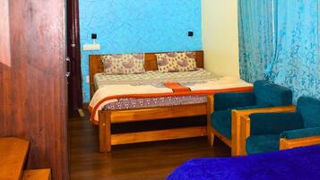 Un dormitorio con una cama de madera, una pared con diseño azul y una cortina azul.