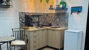 A compact kitchen with a dining area, a sofa, and a small refrigerator. - Luxury house ballaro  (Palermo)