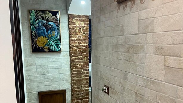 A hallway with a tiled floor, a brick wall, and a wooden door. - Luxury house ballaro  (Palermo)