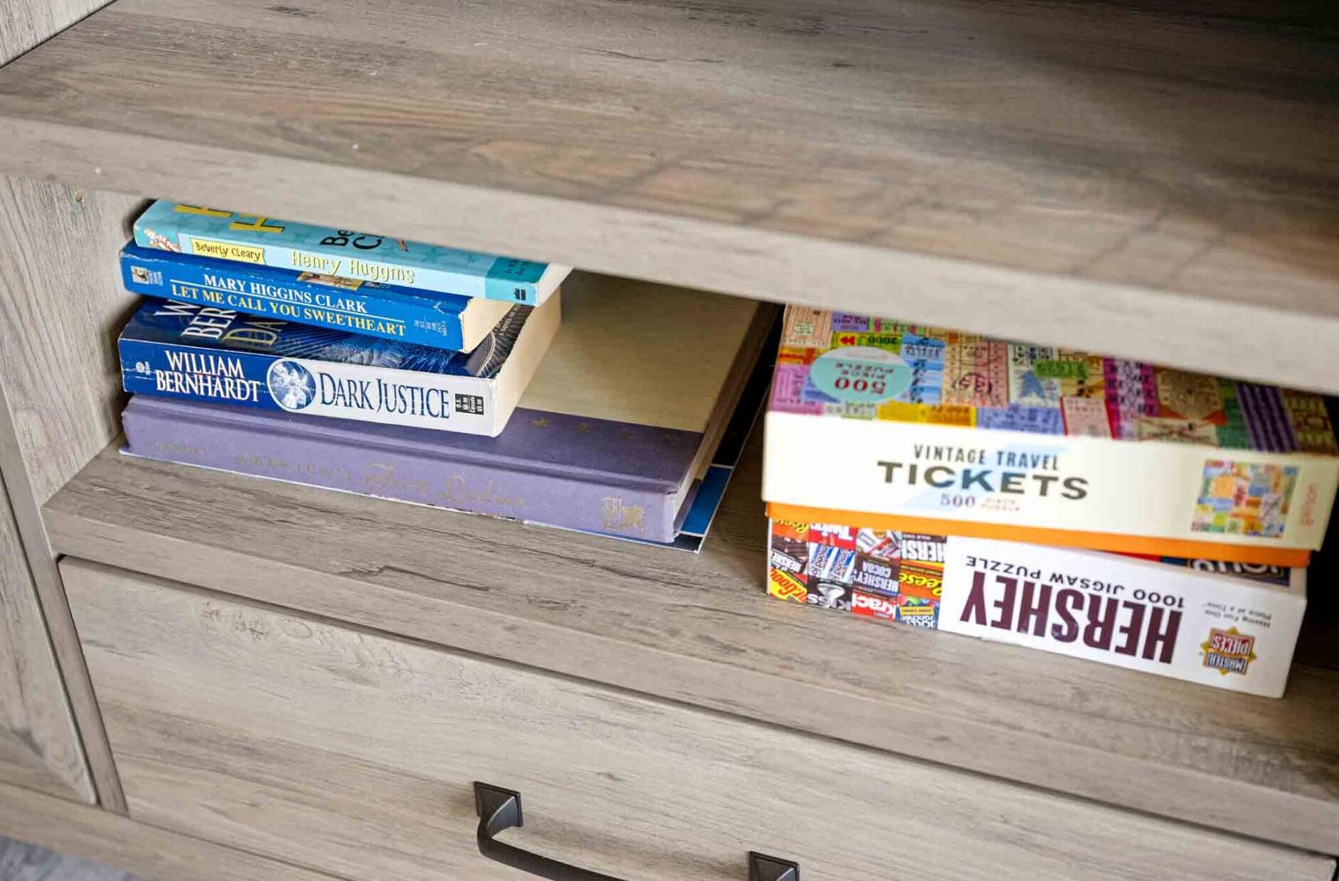 Un tiroir en bois contenant des livres et une boîte remplie de vieux billets de voyage.