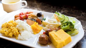 Un plato de comida con arroz, verduras y una taza.