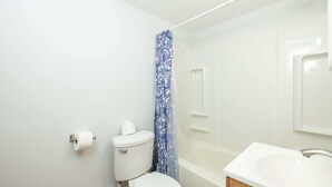 Ein Badezimmer mit Toilette, Duschvorhang und Waschbecken.