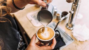 A person pouring milk into a cup of coffee, creating a latte art design. - Studio for 2 in City of Ghent (Gent)