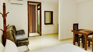 A room with a dining table, chairs, a sofa, and a coat rack. - Easy Stay (Kandy)