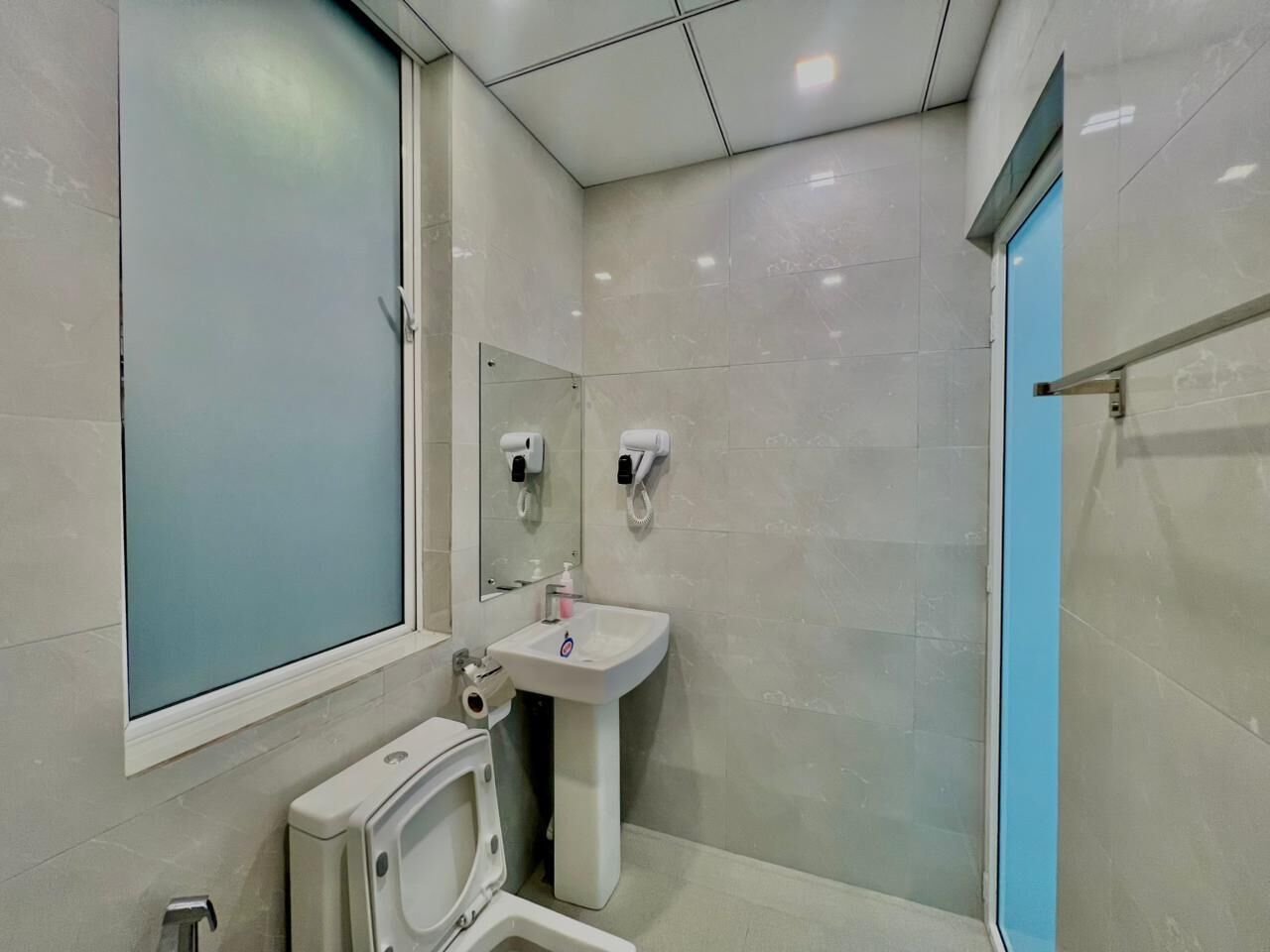 A modern bathroom with a toilet, sink, and shower.