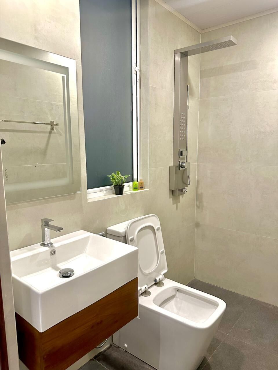 A modern bathroom with a sink, toilet, and shower.