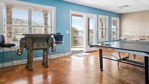 Une pièce avec une table de ping-pong, une statue d’éléphant et une vue sur l’extérieur.