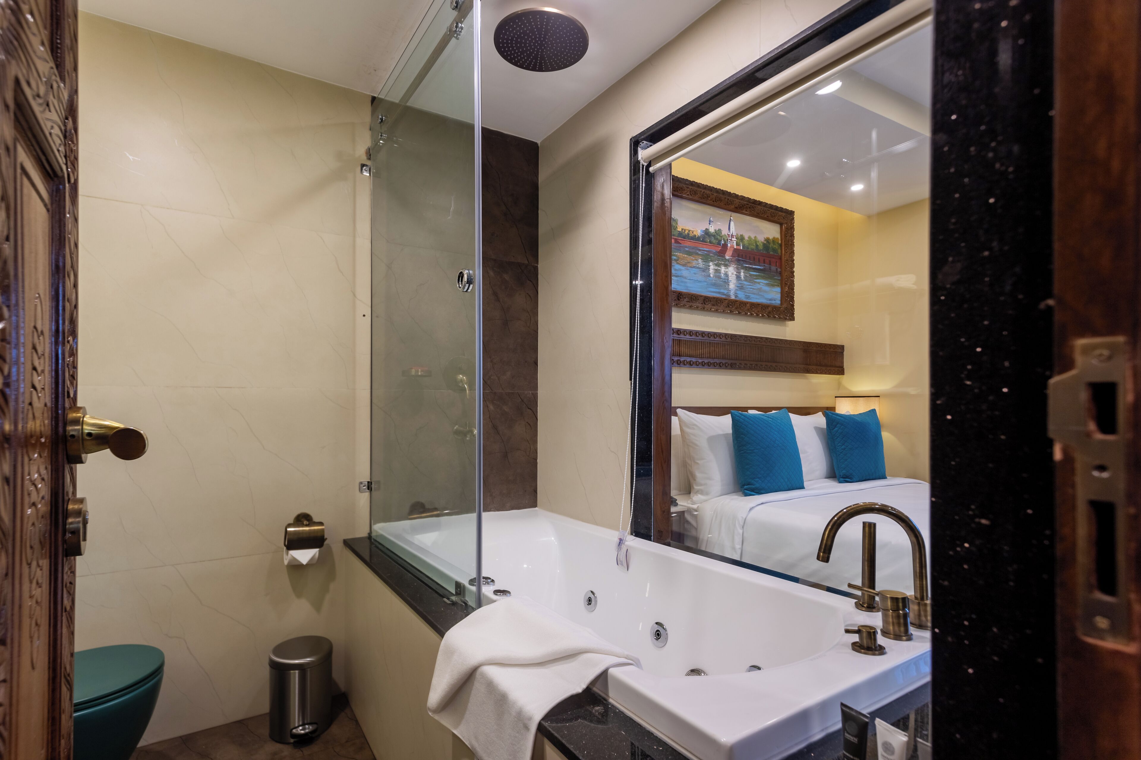 A bathroom with a bathtub, a large mirror, a toilet, and a sink.