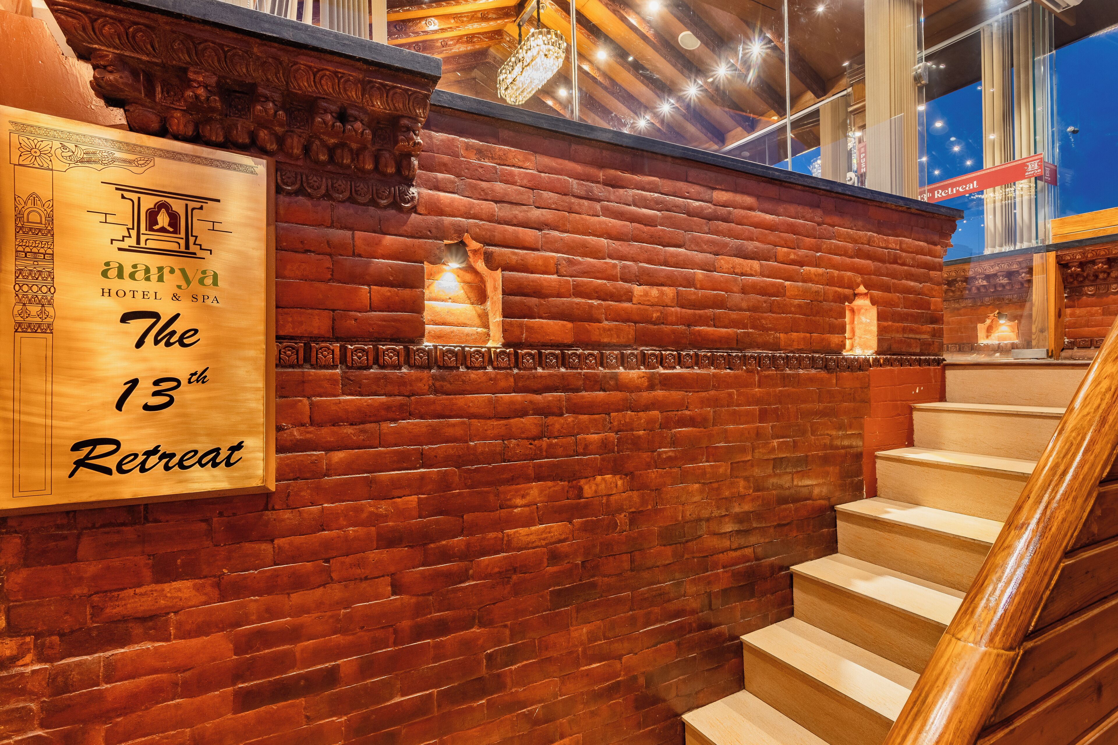 A wooden sign for 'Aarya Hotel & Spa' indicating 'The 13th Retreat'.