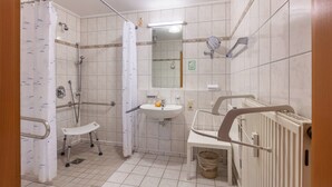 A bathroom with a shower, a sink, a mirror, and a toilet. - Room 'Doppelzimmer 3 - Behindertengerecht' with Shared Terrace and Wi-Fi (Bad Bellingen)