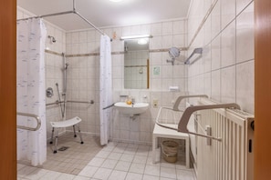 A bathroom with a shower, a sink, a mirror, and a toilet.
