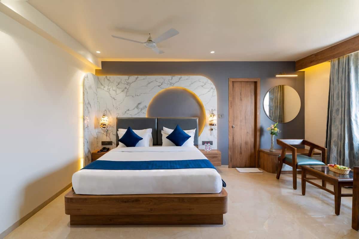 Une chambre d’hôtel moderne avec un grand lit, un bureau et une chaise.
