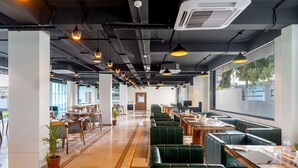 A modern restaurant with high ceilings, pendant lighting, and a mix of booth and table seating. - Redolence Aravali Tree (Udaipur)