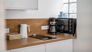 Eine Küche mit Kaffeemaschine, Toaster und einer Teebox auf der Arbeitsfläche.