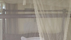 A bed with a white canopy and pillows. - Hillview Heights Haven Guest & Hotel (Webuye)