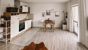 Eine moderne Küche mit weißen Schränken, einem Holztisch und einem Kuhfellteppich.