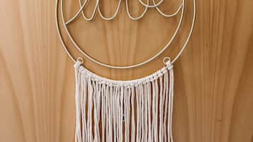 Un tapiz de macramé con la palabra 'love' y un marco circular.