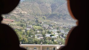 A view of a town with buildings and a mountain in the background. - Kingaling Hotel (Punakha)