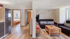 A modern living room with a sofa, a coffee table, and a wall with text. - Apartment Zwergenschlössle with Private Garden and Wi-Fi (Breitnau)