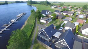 Un quartiere residenziale con case, un molo con barche e un fiume.