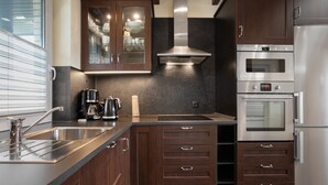 Una cucina moderna con elettrodomestici in acciaio inossidabile, mobili in legno e forno integrato.
