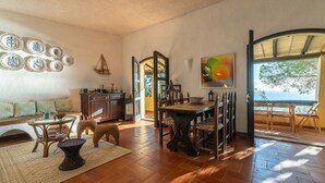 A spacious living area with a dining table, chairs, a sofa, and a fireplace.