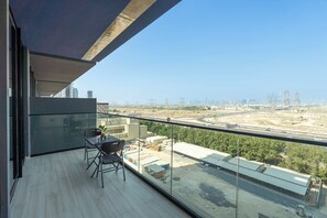 A balcony with a view of a highway and city skyline. - Vogue | Binghatti Corner JVC near Circle Mall (Dubai)