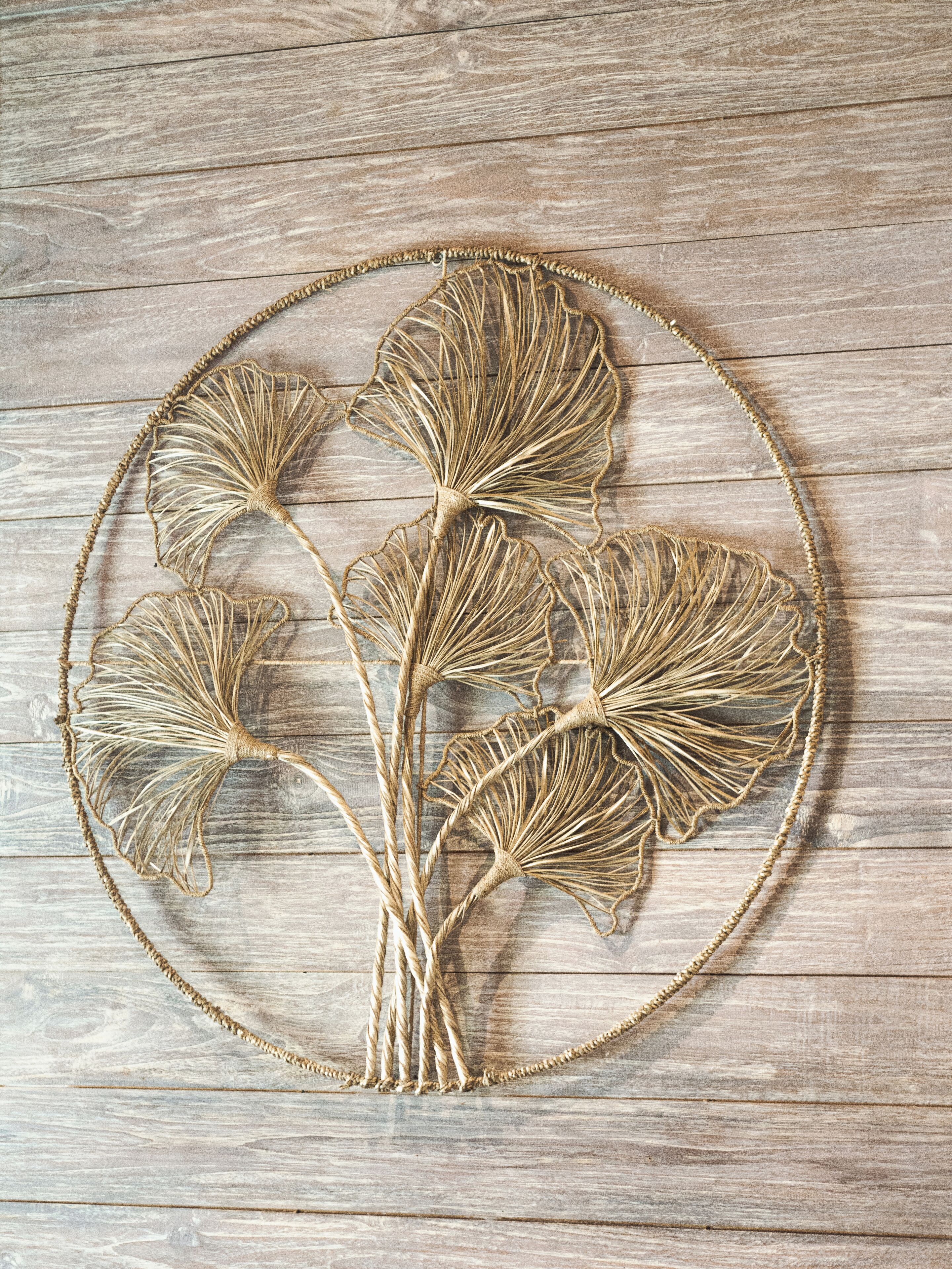 A circular wall hanging with a plant design.