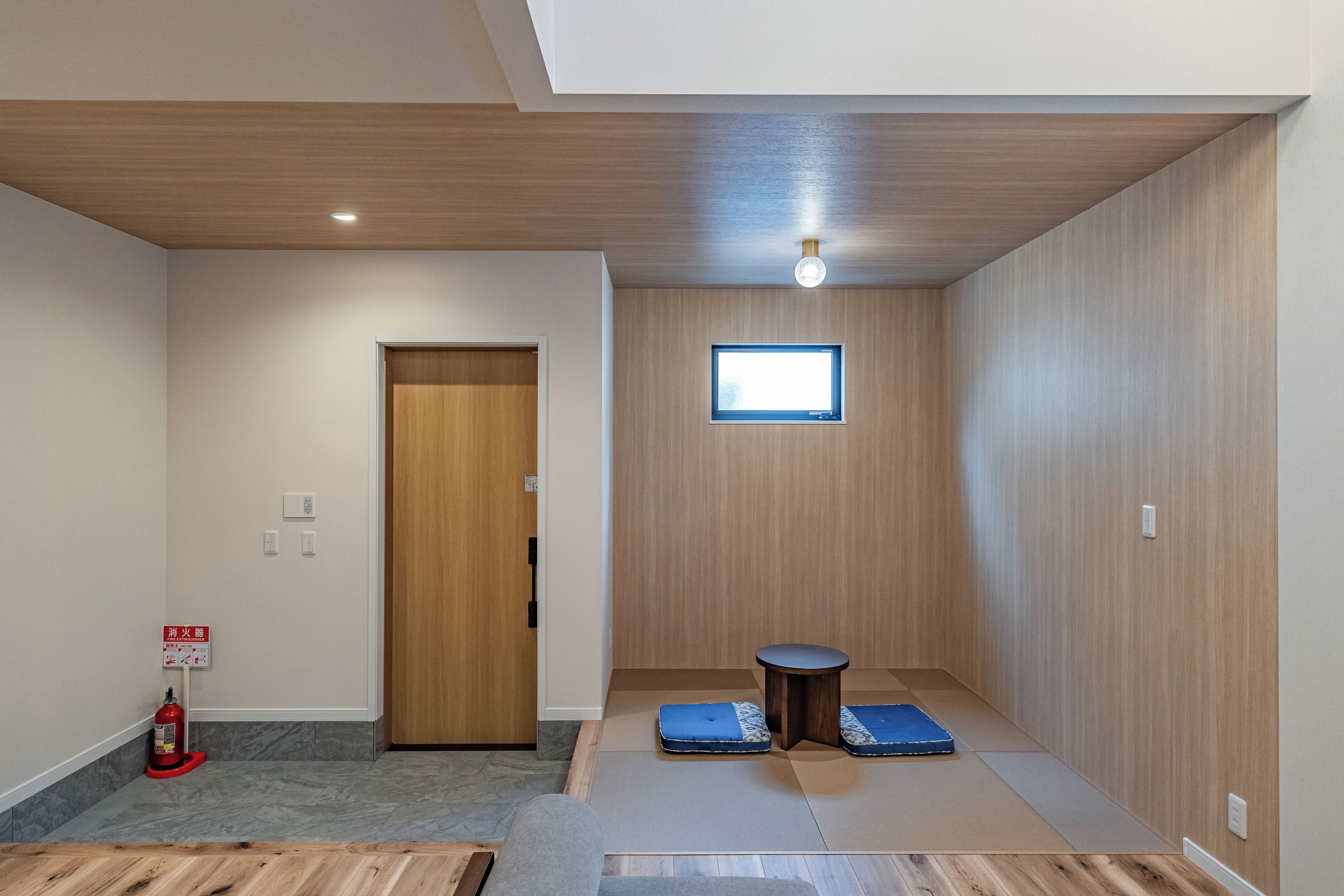 A room with a wooden door, a small table, and a window.