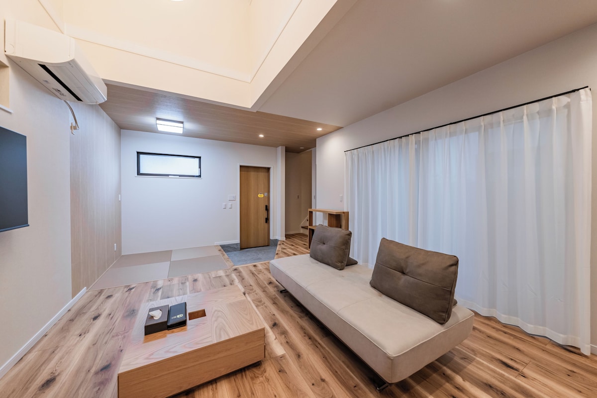 Un salon moderne avec un canapé, une table basse et un téléviseur.
