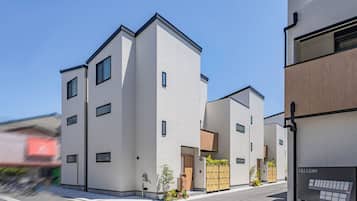 A modern multi-story building with a flat roof, large windows, and a minimalist design.