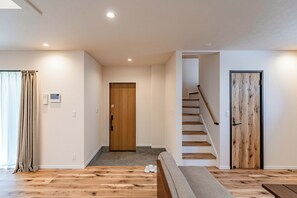 Un intérieur moderne avec un escalier en bois, une porte en bois et un banc.