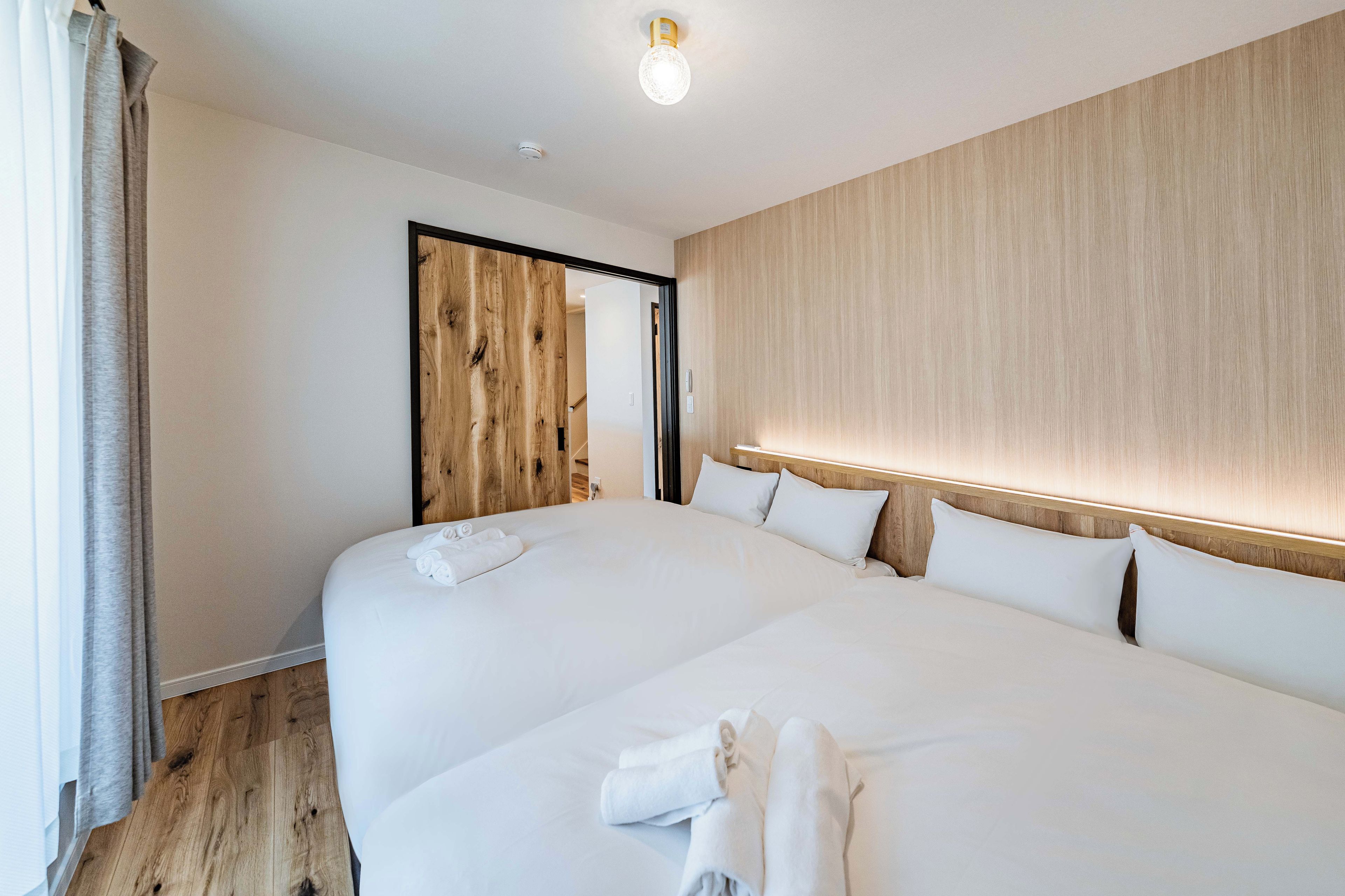 Une chambre d’hôtel avec un grand lit, une tête de lit en bois et un panneau mural en bois.