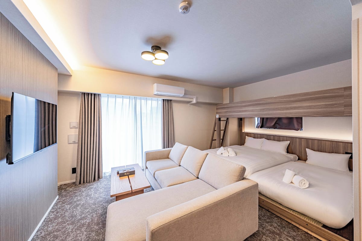 Une chambre d’hôtel équipée d’un canapé, d’un lit, d’une télévision et d’un appareil de climatisation.