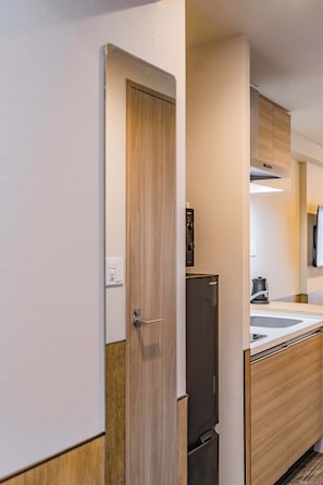Una cocina compacta con refrigerador, microondas y lavamanos.